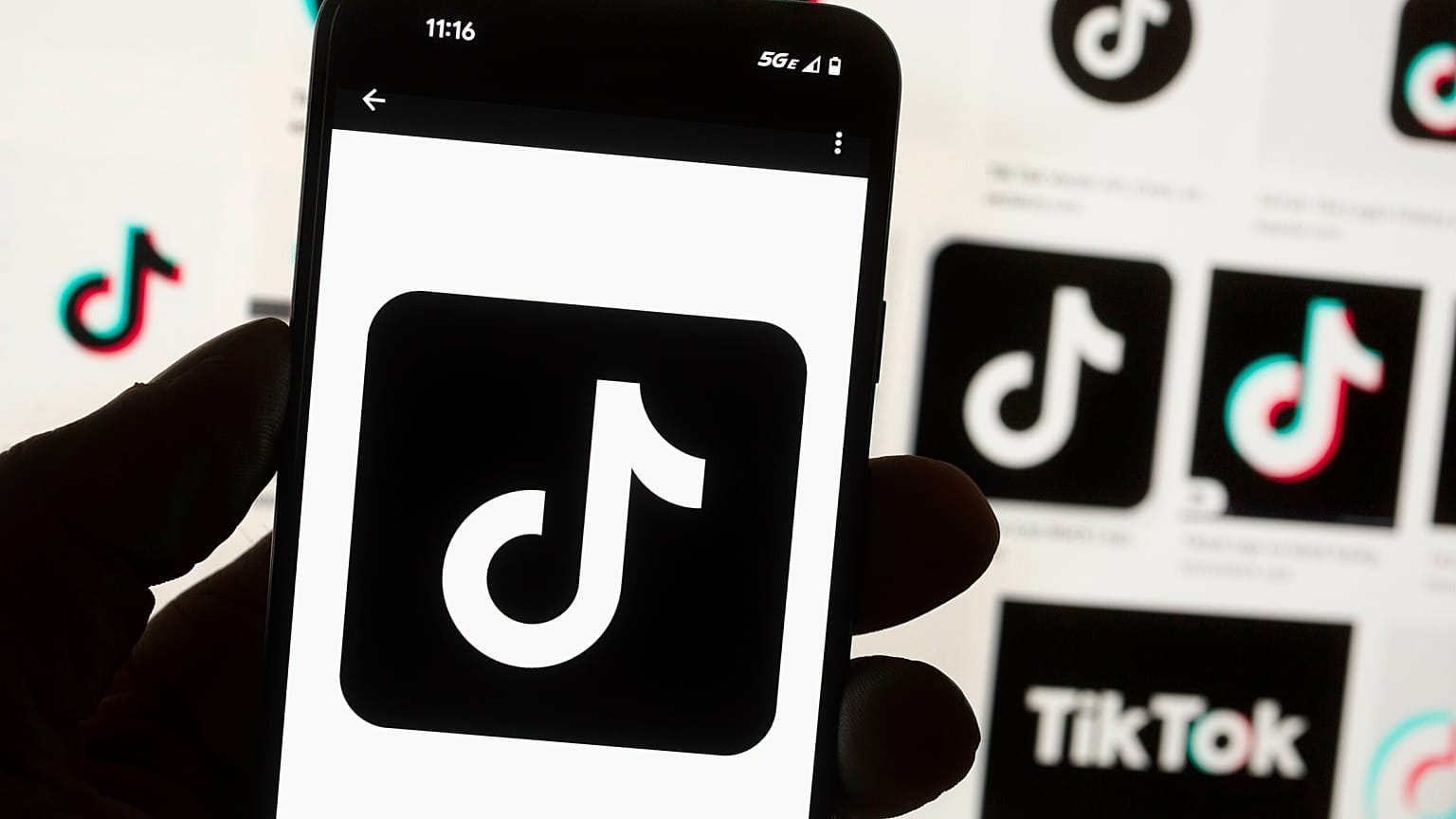 O logótipo do TikTok é apresentado num telemóvel em frente a um ecrã de computador em Boston, 14 de outubro de 2022