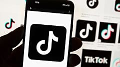 O logótipo do TikTok é apresentado num telemóvel em frente a um ecrã de computador em Boston, 14 de outubro de 2022