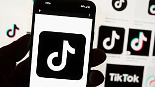 TikTok logosu Boston'da bir bilgisayar ekranı önünde bir cep telefonunda görüntüleniyor, 14 Ekim, 2022