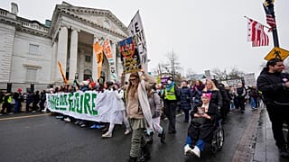 People march past the Daughters of the American Revolution National Headquarters building during the People's March, Saturday, Jan. 18, 2025, in Washington.