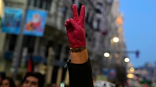 متظاهر يرتدي قفازًا أحمر ويرفع علامة النصر خلال مظاهرة لدعم الفلسطينيين في غزة، في مدريد، إسبانيا 18/01/2025
