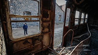 Mazen Malla junto a uma carruagem destruída na estação
