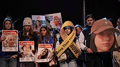 Menschen halten Porträts von Geiseln auf der Bühne während einer Kundgebung in Paris, 18. Januar 2025