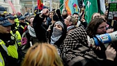 People hold flags and placards as they are are contained by police officers, during a rally in support of the Palestinian People in Gaza, in London, Saturday, Jan. 18, 2025.
