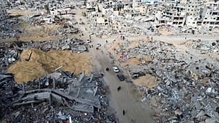 فلسطينيون يسيرون وسط الدمار المروع بمدينة رفح جنوب قطاع غزة مع دخول وقف النار حير التنفيذ. 19/01/2025