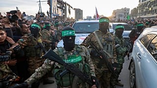 مقاتلو حماس يرافقون سيارة تابعة للصليب الأحمر لتسلم الأسرى الإسرائيليين الذين تم الإفراج عنهم بعد دخول اتفاق وقف إطلاق النار بين إسرائيل وحماس حيز التنفيذ، في مدينة غزة، 2025
