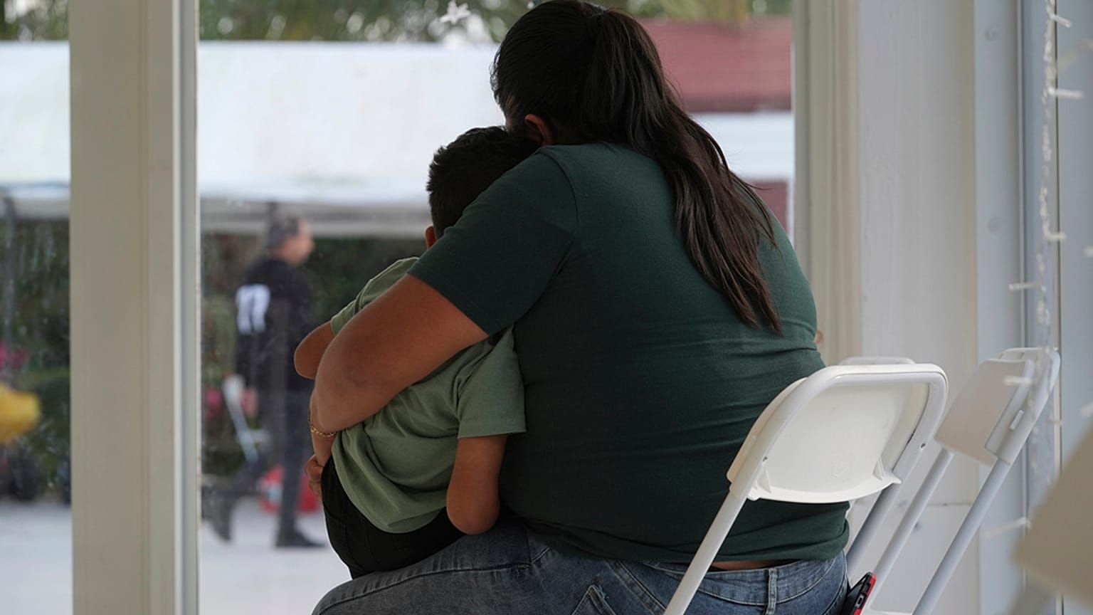 Madre inmigrante con su hijo en las instalaciones fronterizas de Estados Unidos.