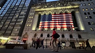 İnsanlar New York'taki New York Borsası'nın önünden geçiyor.