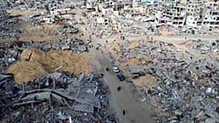 فلسطينيون يسيرون وسط الدمار الذي خلفته الهجمات الجوية والأرضية الإسرائيلية في رفح بعد اتفاق وقف إطلاق النار في قطاع غزة 19 كانون الثاني يناير 2025
