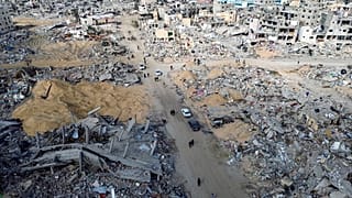 فلسطينيون يسيرون وسط الدمار الذي خلفته الهجمات الجوية والأرضية الإسرائيلية في رفح بعد اتفاق وقف إطلاق النار في قطاع غزة 19 كانون الثاني يناير 2025