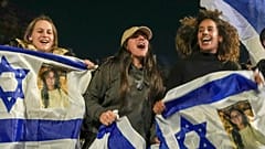 Israelis feiern die Freilassung von drei Geiseln, die von der Hamas im Gazastreifen gefangen gehalten wurden, während sie sich in Tel Aviv, Israel, versammeln, Sonntag, 19. Januar 2025
