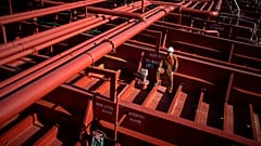 Rahil Gunawan posa en la cubierta del buque tanque químico en el que trabaja como marinero mientras hace escala en el puerto de Barcelona, ​​España.