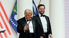 O Presidente Donald Trump, à esquerda, segura um sabre depois de o usar para cortar um bolo no Baile do Comandante, parte da 60ª Inauguração Presidencial.