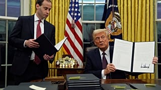 الرئيس دونالد ترامب يحمل أمرًا تنفيذيًا في المكتب البيضاوي في البيت الأبيض، يوم الاثنين 20 يناير/كانون الثاني 2025، في واشنطن. 
