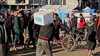 Un palestinese esce con un pacco di aiuti alimentari, Khan Younis, Gaza, 20.01.2025