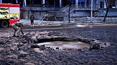 A Ukrainian serviceman collects evidence following a Russian missile attack in Kyiv, Ukraine, Saturday, Jan. 18, 2025.