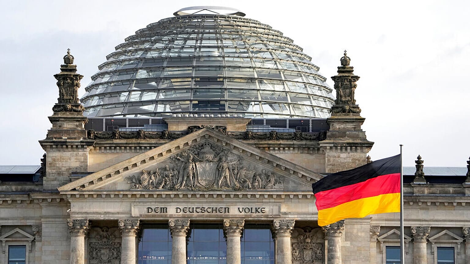 Un drapeau national allemand flotte devant le bâtiment du Reichstag, siège du Parlement fédéral allemand Bundestag, à Berlin, Allemagne, lundi 3 janvier 2022. 