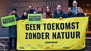 Funcionários da Greenpeace em frente ao Palácio da Justiça, em Haia, com uma faixa onde se lê "Não há futuro sem natureza" e "Protejam a nossa natureza".