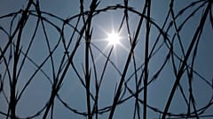 O sol brilha através do arame de concertina numa vedação da Penitenciária Estatal do Louisiana em Angola, Laos, a 26 de abril de 2014.