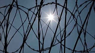 O sol brilha através do arame de concertina numa vedação da Penitenciária Estatal do Louisiana em Angola, Laos, a 26 de abril de 2014.
