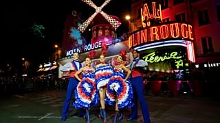 Des danseurs se produisent devant le cabaret du Moulin Rouge lors de l'inauguration du moulin à vent du théâtre, à Paris, le vendredi 5 juillet 2024.