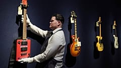 An art handler displays a Bohemian Guitars novelty electric guitar (Atlanta, Georgia, circa 2015) in London on Tuesday, 14 January 2025.
