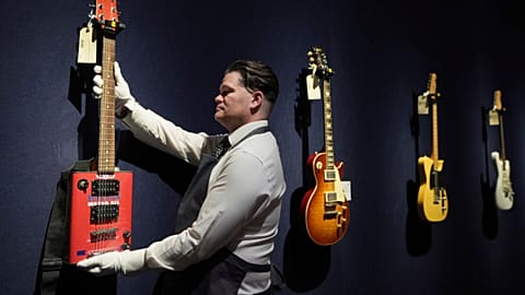 An art handler displays a Bohemian Guitars novelty electric guitar (Atlanta, Georgia, circa 2015) in London on Tuesday, 14 January 2025.