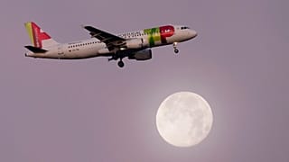 Un Airbus A320 de TAP Air Portugal se aproxima para aterrizar en Lisboa, Portugal, con la luna llena de fondo. 16 de diciembre de 2024.