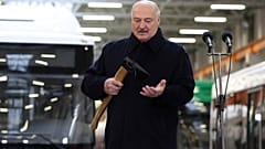 Lukaschenko hält eine Axt bei einem Treffen mit Mitarbeitern des Minsker Automobilwerks (MAZ) in Minsk am 21. Januar 2025