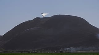 Un hélicoptère largue de l'eau sur les flammes à Camarillo où l'incendie de Laguna s'est déclaré, en Californie aux États-Unis, le 23.01.2025