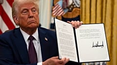 Präsident Donald Trump hält einen Gnadenerlass für Abtreibungsgegner hoch, während er im Oval Office des Weißen Hauses Ausführungsbestimmungen unterzeichnet, Donnerstag, 23. Januar 2025