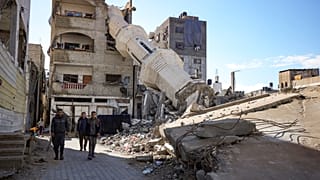 Palestinos pasan frente a una mezquita destruida por los ataques aéreos israelíes en Nuseirat, Franja de Gaza, el viernes 24 de enero de 2025