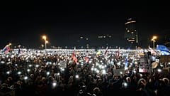 Tausende von Menschen versammeln sich in Bratislava, um gegen die Politik des populistischen Premierministers Robert Fico zu protestieren, 24. Januar 2025, und zünden ihre Telefone an.