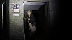 Eine ältere Frau verlässt ihr beschädigtes Haus nach einem Raketenangriff in Saporischschja, Ukraine, Donnerstag, 23. Januar 2025. 