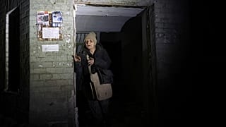 Yaşlı bir kadın 23 Ocak 2025 Perşembe günü Ukrayna'nın Zaporizhzhia kentindeki füze saldırısının ardından hasar gören evini terk ediyor. 