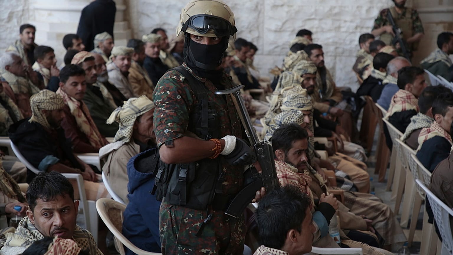 جندي من قوات الحوثي يرافق السجناء المفرج عنهم الموالين للحكومة اليمنية بعد إطلاق سراحهم، في صنعاء، اليمن، السبت، 25 يناير/كانون الثاني 2025.