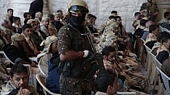جندي من قوات الحوثي يرافق السجناء المفرج عنهم الموالين للحكومة اليمنية بعد إطلاق سراحهم، في صنعاء، اليمن، السبت، 25 يناير/كانون الثاني 2025.
