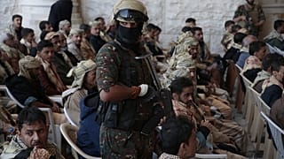 جندي من قوات الحوثي يرافق السجناء المفرج عنهم الموالين للحكومة اليمنية بعد إطلاق سراحهم، في صنعاء، اليمن، السبت، 25 يناير/كانون الثاني 2025.
