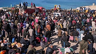 Palestinianos esperam com os seus pertences no centro de Gaza na esperança de regressar ao norte, 25 de janeiro de 2025