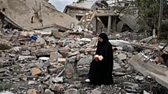 Una mujer libanesa se sienta sobre los escombros de una casa destruida por la ofensiva israelí, en Aita al-Shaab, en la frontera sur de Líbano