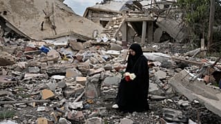 Una mujer libanesa se sienta sobre los escombros de una casa destruida por la ofensiva israelí, en Aita al-Shaab, en la frontera sur de Líbano