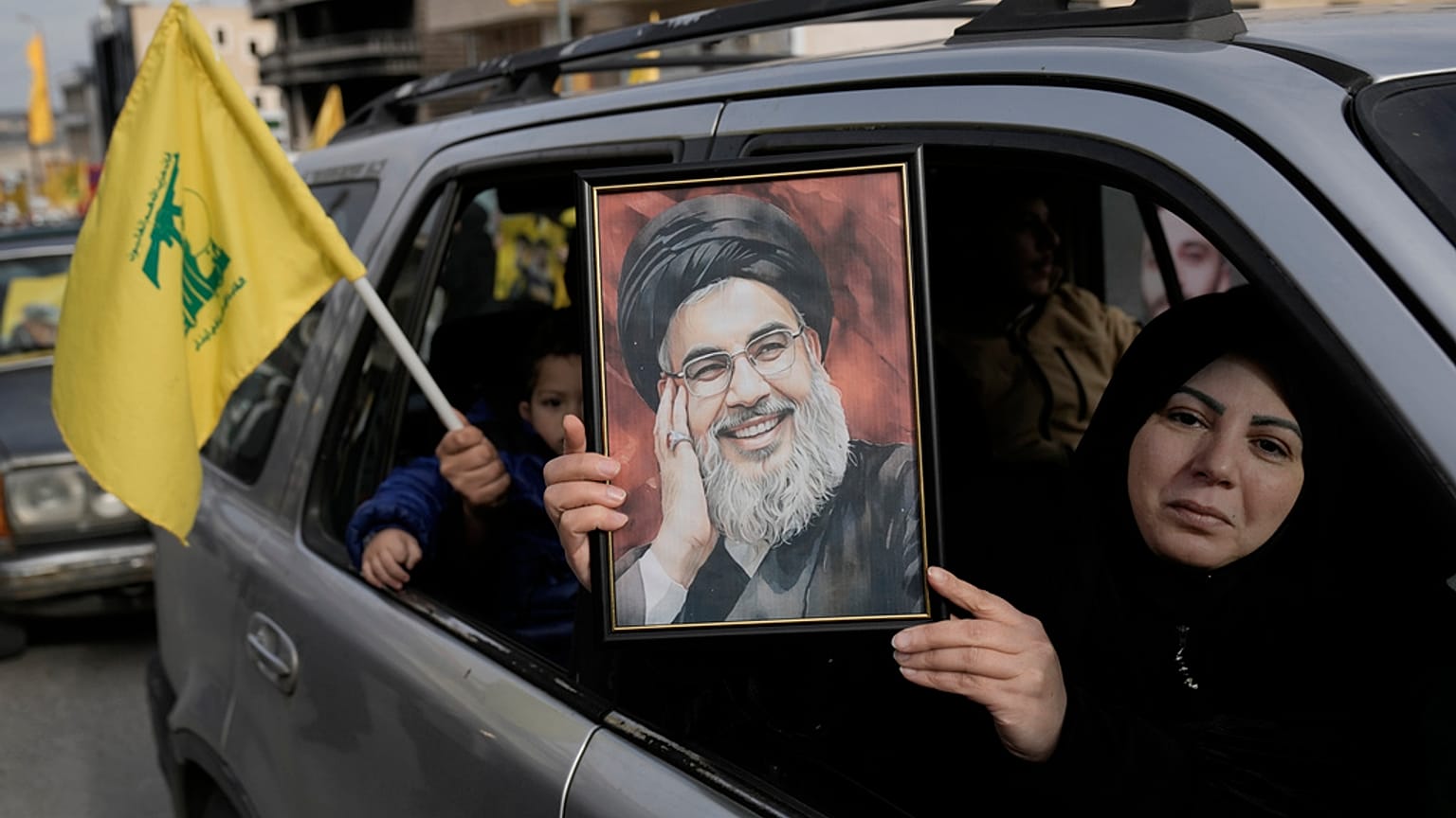 Egy nő a meggyilkolt Hezbollah-vezér, Naszrallah portréját tartja a kezében Dél-Libanonban