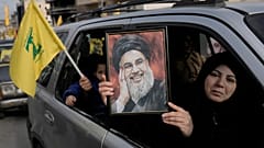 Egy nő a meggyilkolt Hezbollah-vezér, Naszrallah portréját tartja a kezében Dél-Libanonban