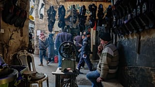 Um comerciante sentado no interior da sua loja no mercado da cidade velha de Damasco, 9 de janeiro de 2025