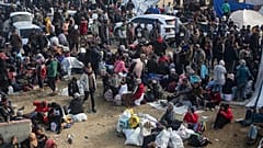 Vertriebene Palästinenser versammeln sich mit ihren Habseligkeiten in der Nähe einer Straßensperre, während sie darauf warten, in ihre Häuser im nördlichen Teil des Gazastreifens zurückzukehren, 26. Januar 2025