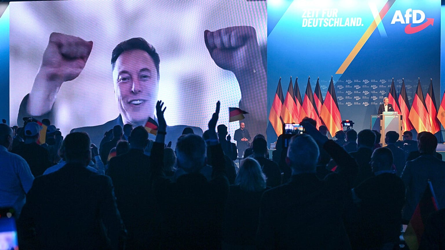 Elon Musk amerikai üzletember élő videókapcsolat közben látható, amint Alice Weidel, az AfD kancellárjelöltje színpadra lép az AfD választási kampánynyitóján.