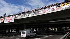 Students stand on a bridge during a student-led strike as they block an intersection for 24 hours to protest the deaths of 15 people killed in the November collapse of a train