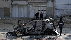 People view wreckage of a vehicle destroyed in an Israeli strike that killed two people in the West Bank refugee camp of Nur Shams, Tulkarem, Monday, Jan. 27, 2025. 
