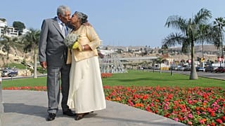 Um casal feliz a posar para uma fotografia.