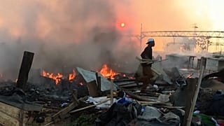 Une personne récupère ce qu'il reste de l'incendie qui a ravagé le quartier de Booysens à Johannesburg en Afrique du Sud, le 27.01.2025